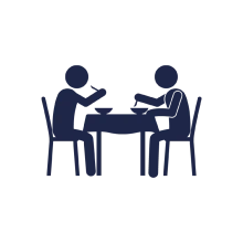 Two people having a meal sitting down at a table icon